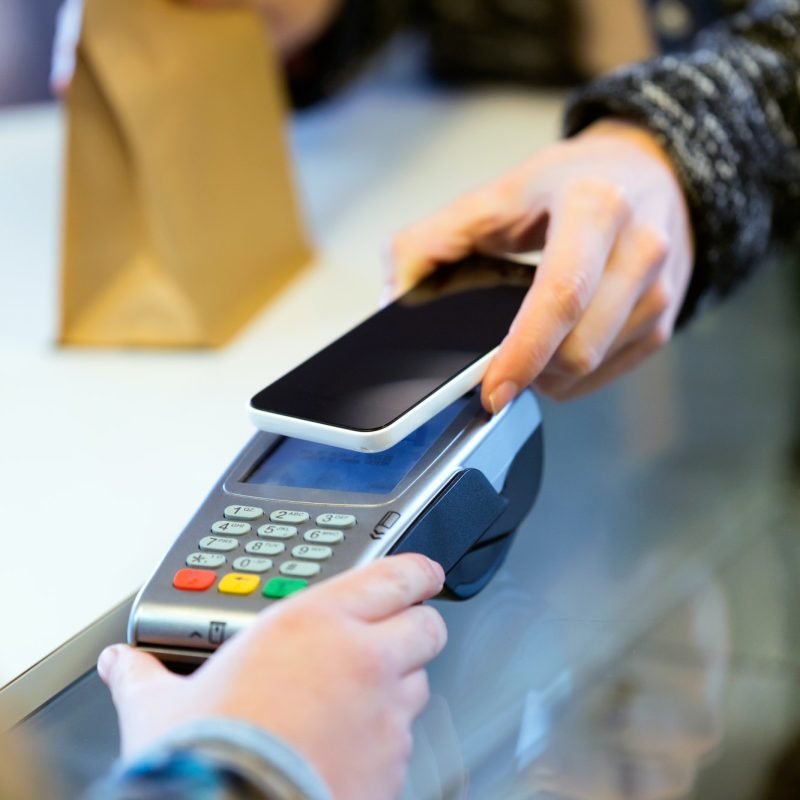 customer-using-her-smartphone-to-make-mobile-payment-with-electr