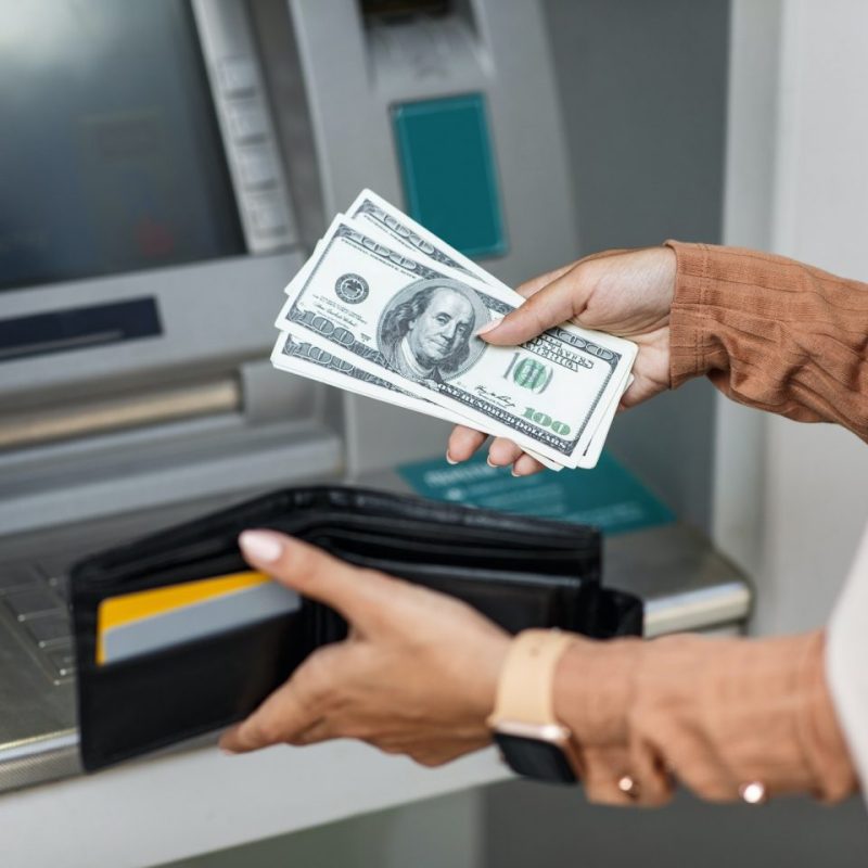 young-woman-withdrawing-money-from-credit-card-at-atm-e1655014574794